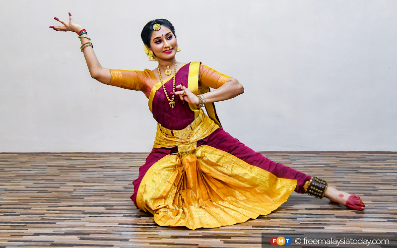 Bharatnatyam dancer in a saraswati pose during her performance on a dark  background. - SuperStock