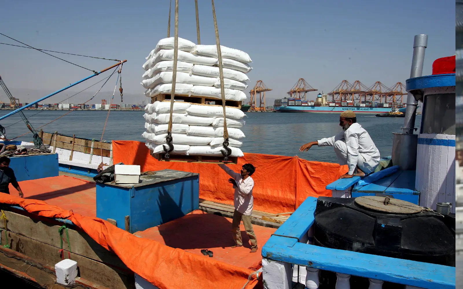 An Indian dhow captain supervises the loading of Omani refined flour aboard a dhow destined for India at the container port of Salalah, Oman, 24 October 2005 (reissued 20 March 2026). 70% of the maritime shipping in the Strait of Hormuz has declined since tensions in the Persian Gulf Region increased on 28 February 2026. According to the International Food Policy Research Institute IFPRI, a prolonged closure of the Strait of Hormuz could affect fertilizers and food production costs, with 30% of global fertilizer passing through the Strait. EPA/MIKE NELSON *** Local Caption *** 00565448